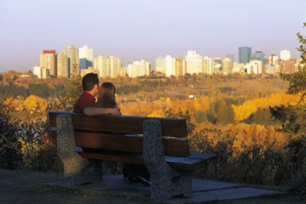 Couple on a bench overlooking Edmonton after realizing why they should live in Edmonton neighbourhoods.
