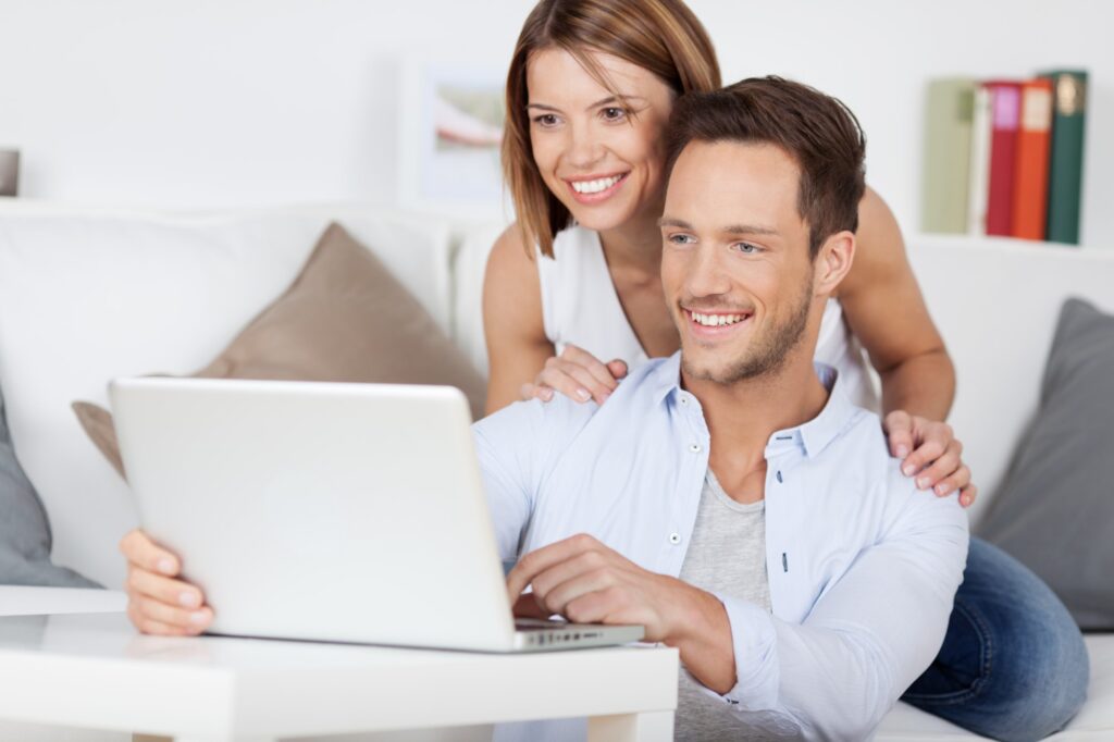 Couple browsing real estate websites for the best Edmonton neighbourhoods.